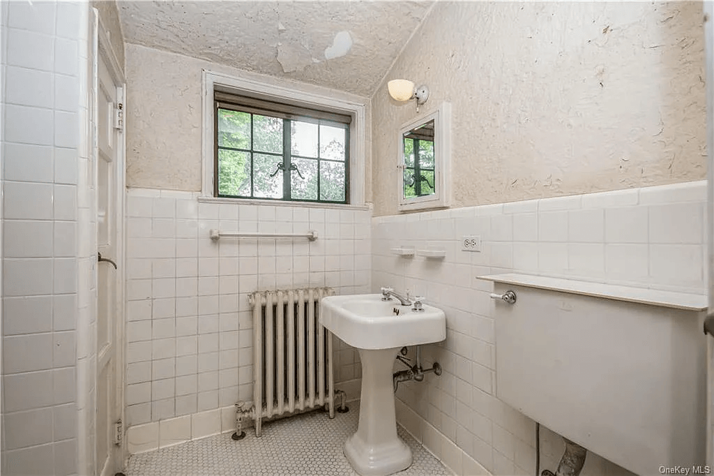 bathroom with white wall tile and a vintage sink and toilet