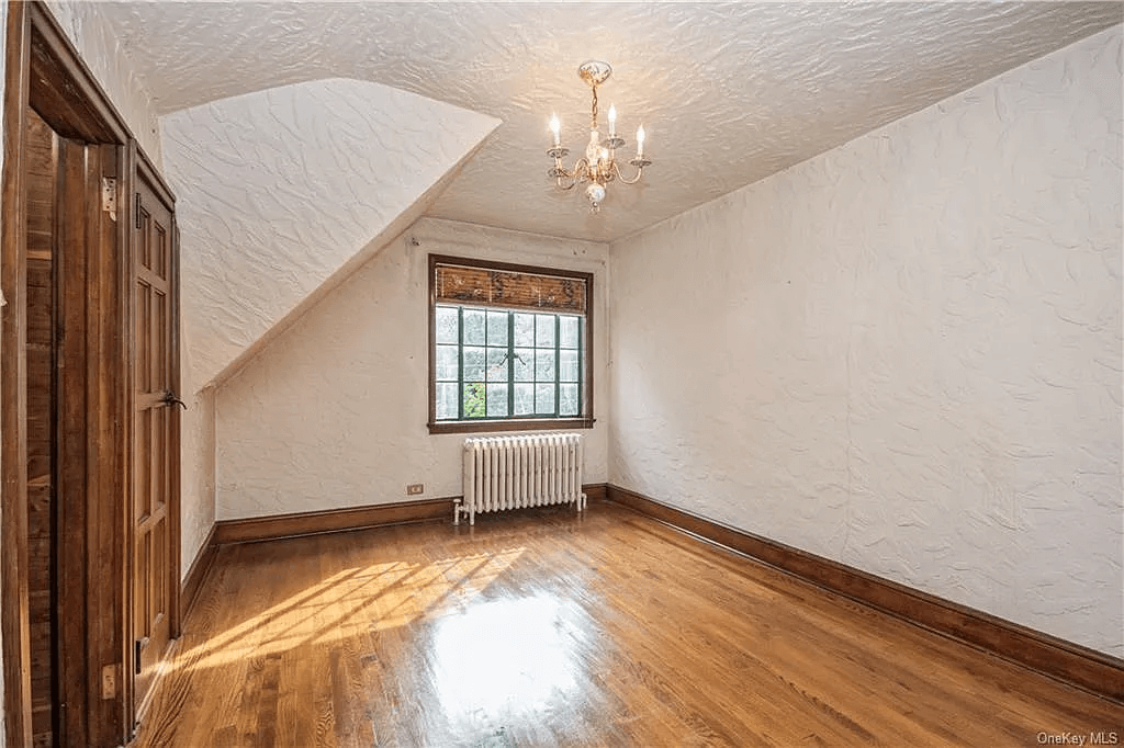 bedroom with a window, sloped ceiling and a wood lined closet