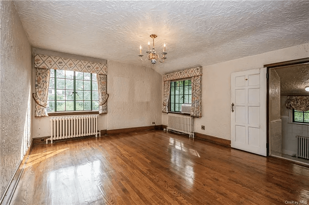 bedroom with steps down to attached bathroom