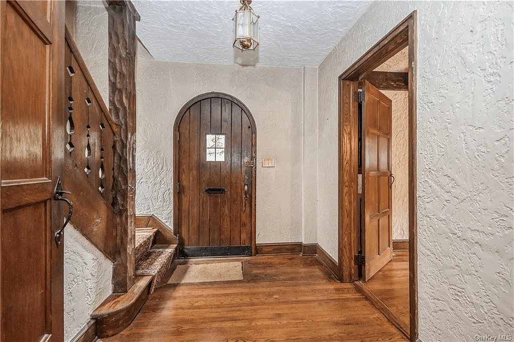 view of front entry hall with arched front door and door into living room