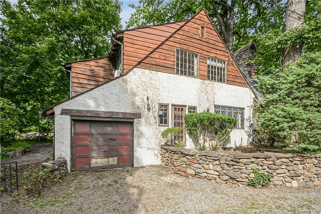 rear facade with stucco lower floor and wood sided upper level and a built-in garage