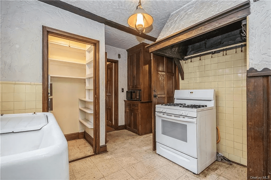 kitchen with yellow tile walls and stove nook