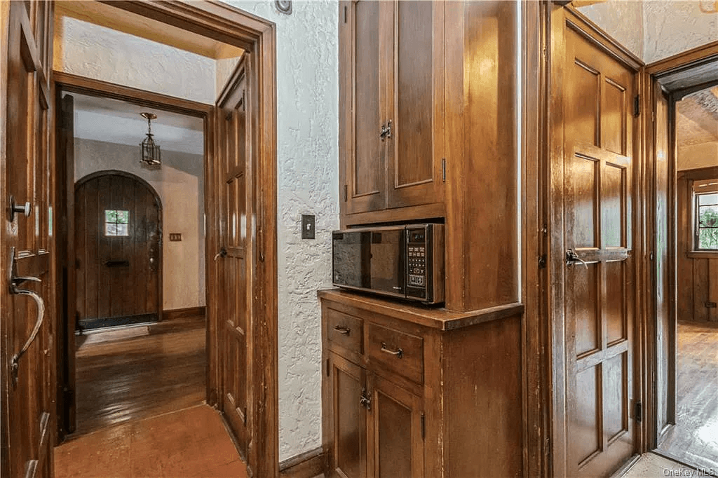 wood cabinets in the kitchen and a vew to the front entrance and hall