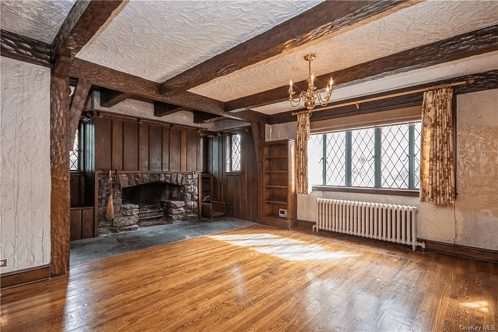 living room with leaded glass windows and a stone fireplace