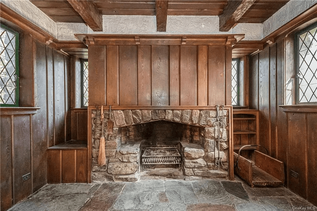 stone fireplace with wood wall above