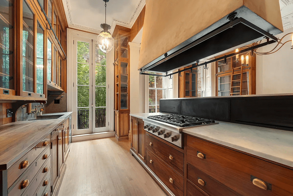 the parlor level kitchen with wood cabinets and glass upper cabinets and french doors to garden