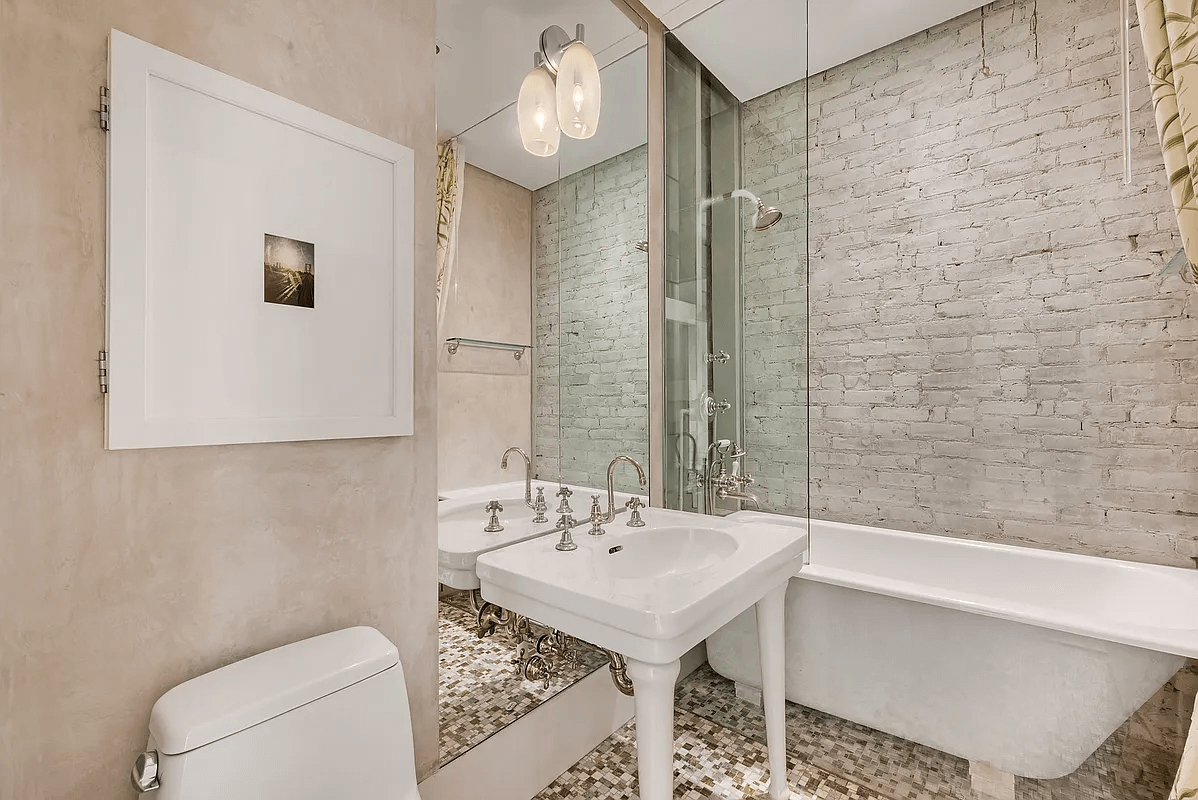 bathroom with tub, glass shower wall and white fixtures