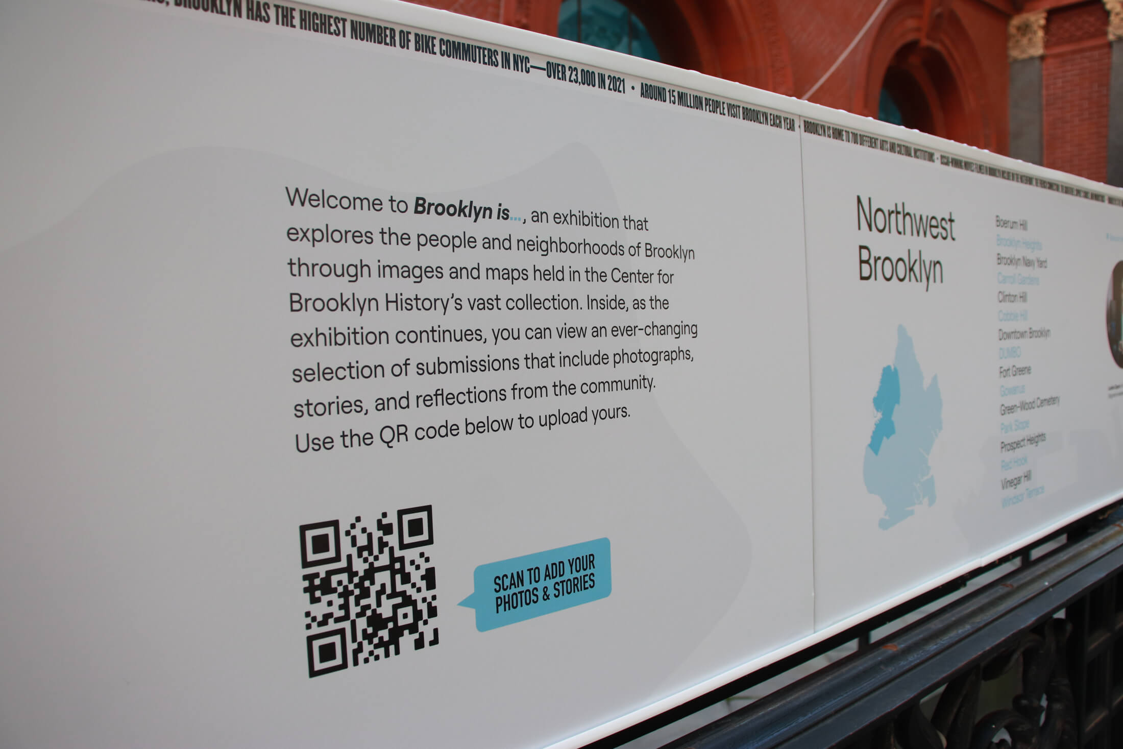 exhibit on the fence includes a QR code for people to add their own photos and stories