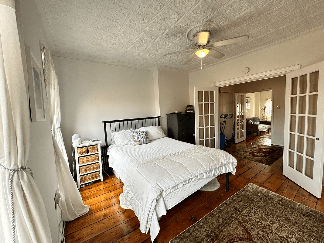 bedroom with french doors, tin ceiling and ceiling fan