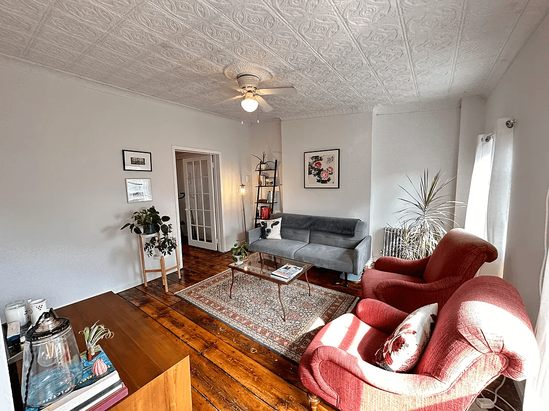 columbia waterfront district - living room with ceiling fan and a tin ceiling