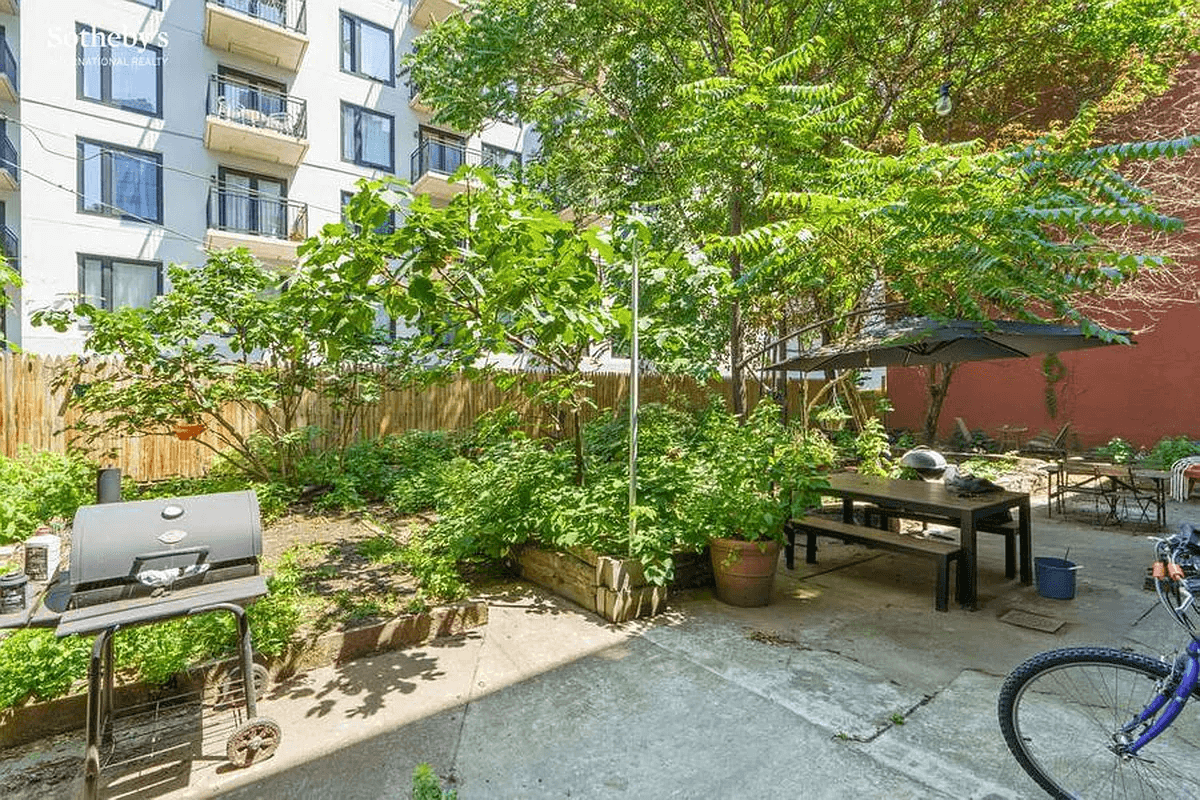 paved rear yard with planting beds