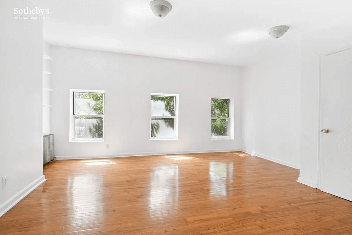 room with wood floors and three windows