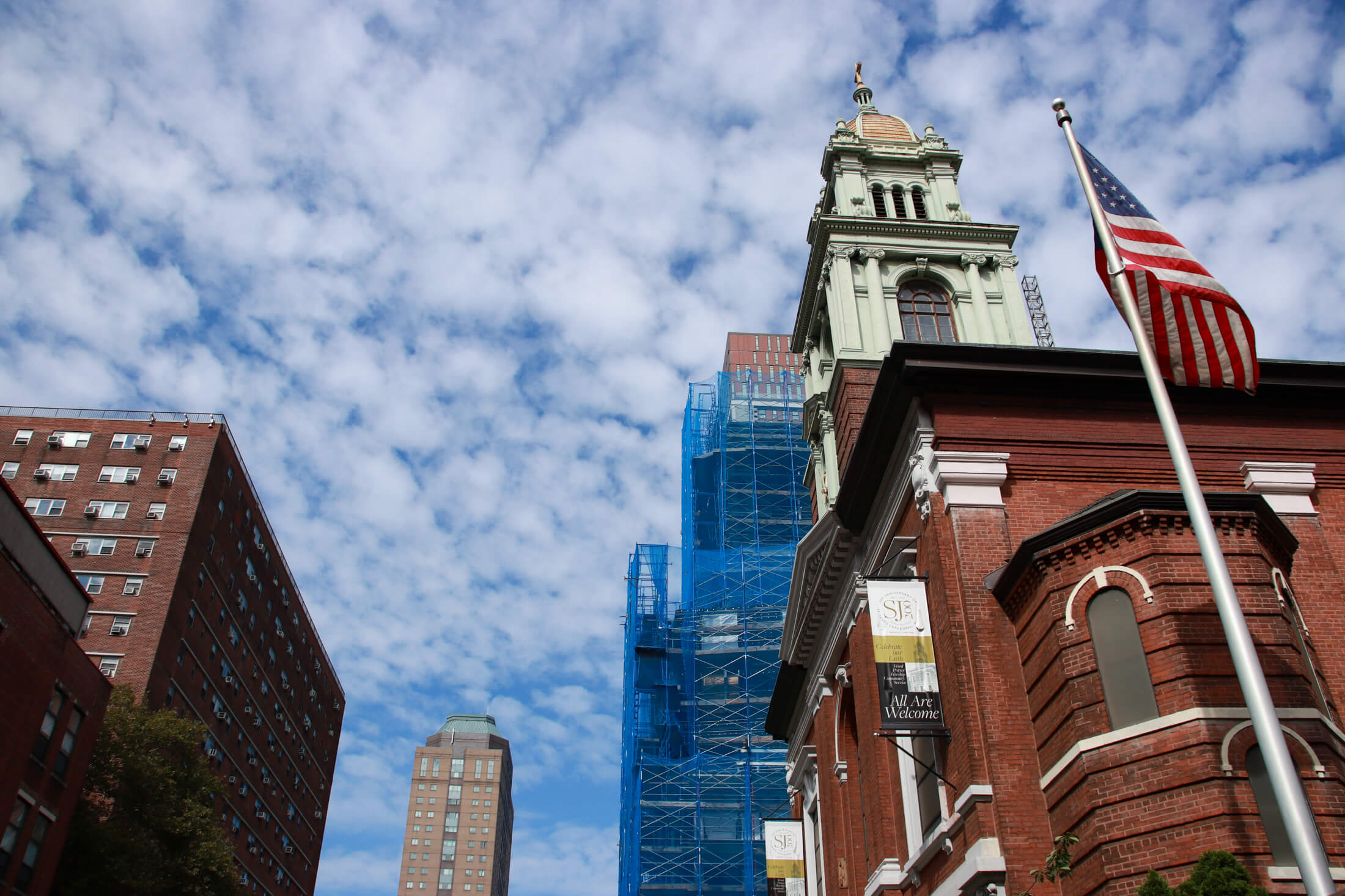 brooklyn - blue sky with view of a flag flying in front of st james cathedram and construction in the background