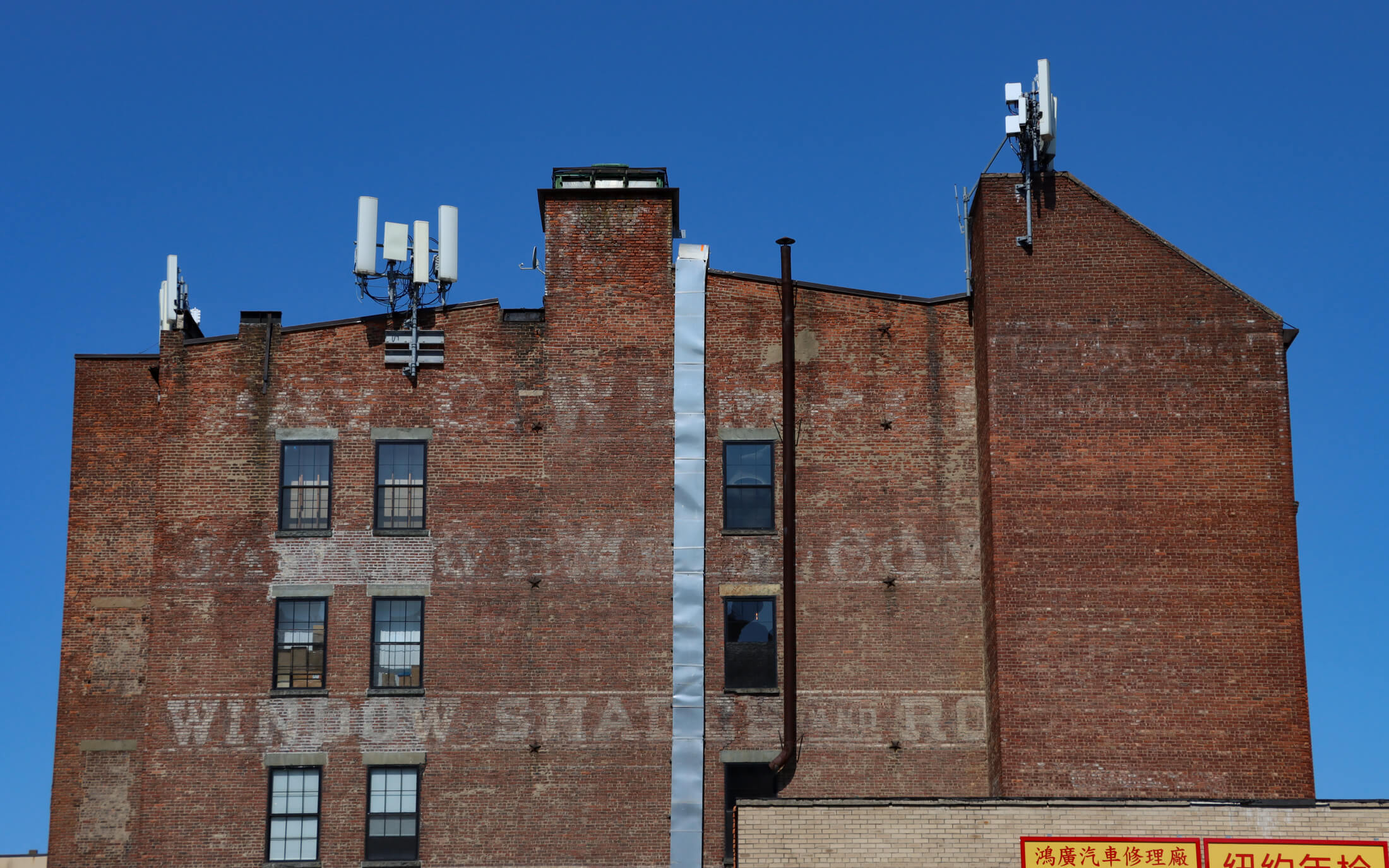 brooklyn - ghost of a painted sign for window shades on a brick building