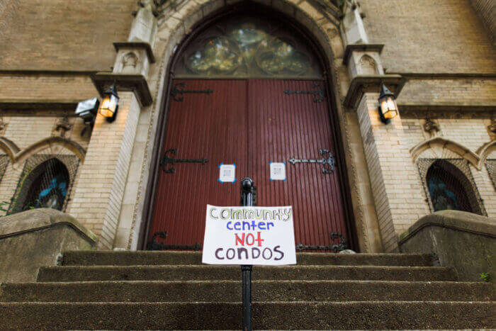 park church - front door of the church with sign saying community center not condos