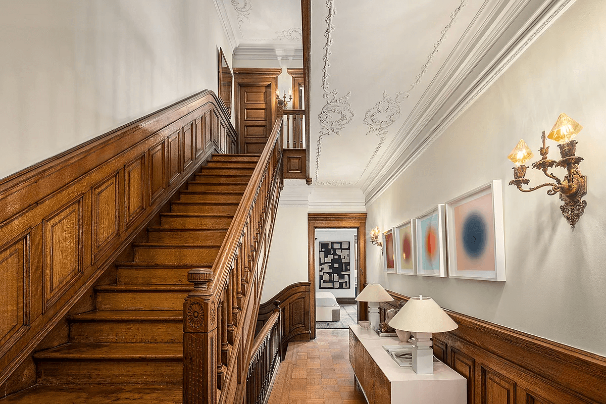 staircase and hallway with plasterwork ceiling