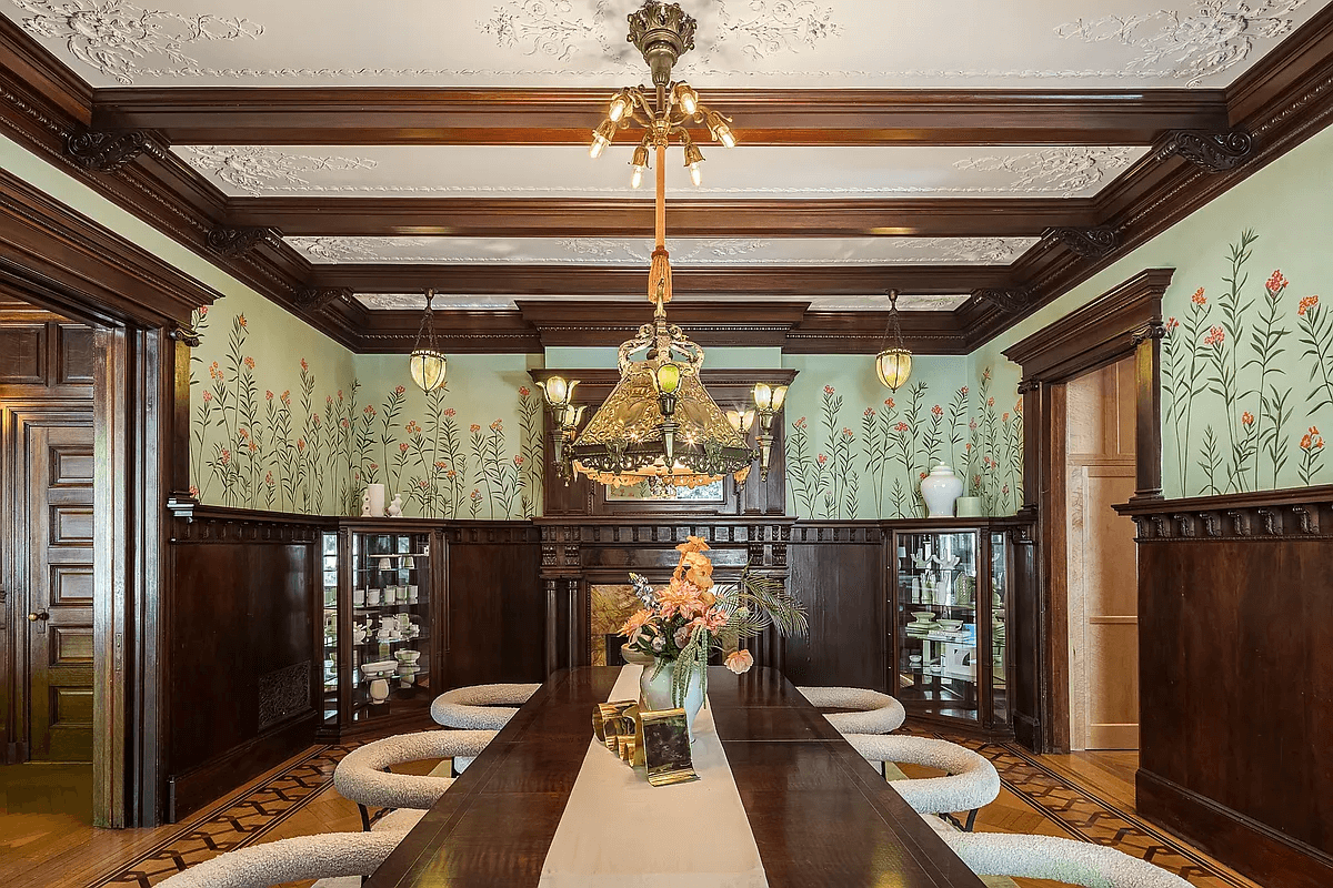 dining room with beamed ceiling, mantel and floral wall ornament above wainscoting