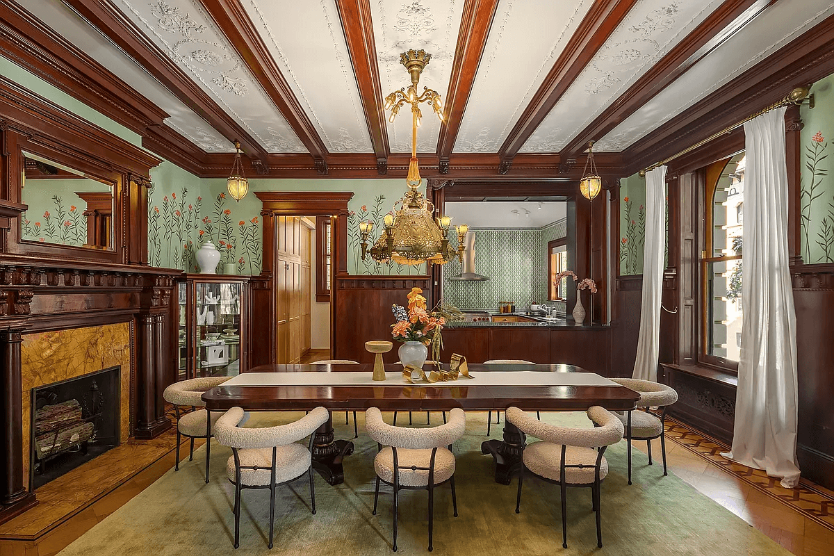 dining room with beamed ceiling, mantel and floral wall ornament above wainscoting