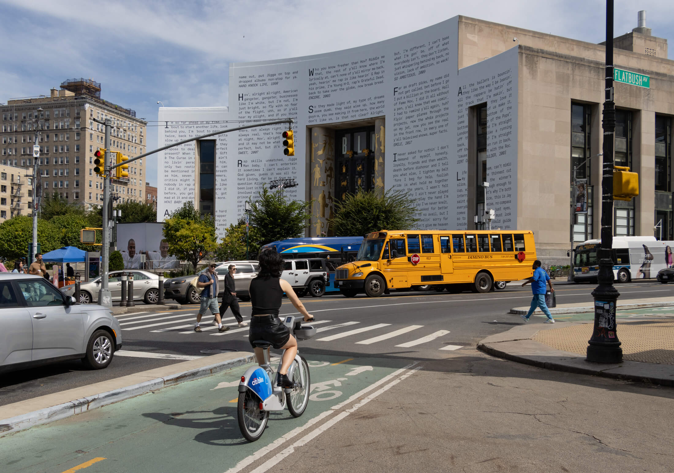 cyclist at grand army plaza with view of brooklyn public library in the backgroun
