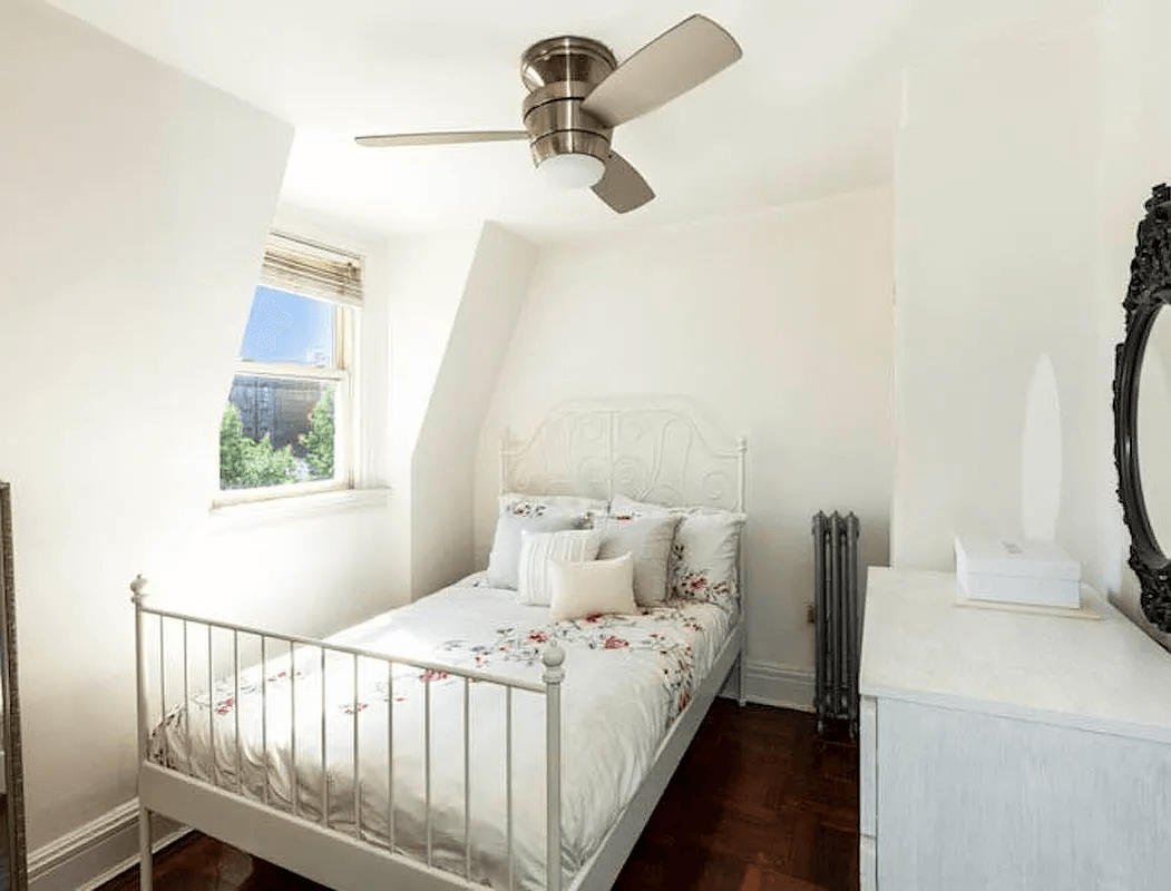 narrow bedroom with a window and a ceiling fan