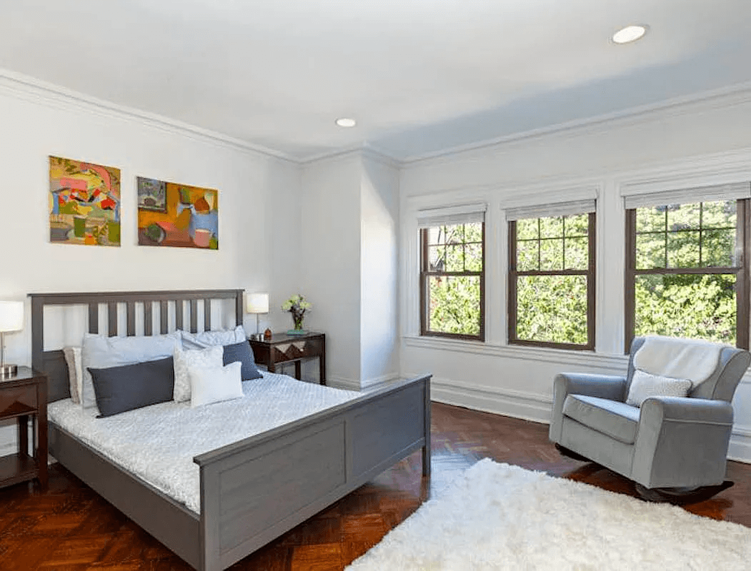 bedroom with wood floors, recessed lighting and three windows