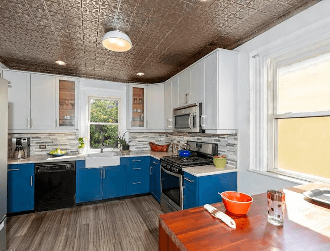 kitchen with tin ceiling, blue lower cabinets and white uppers