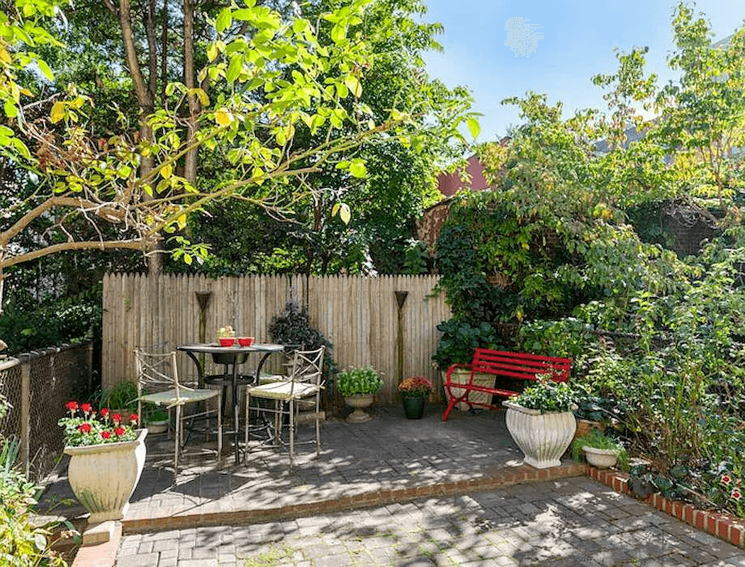 paved rear yard with planting beds on either side