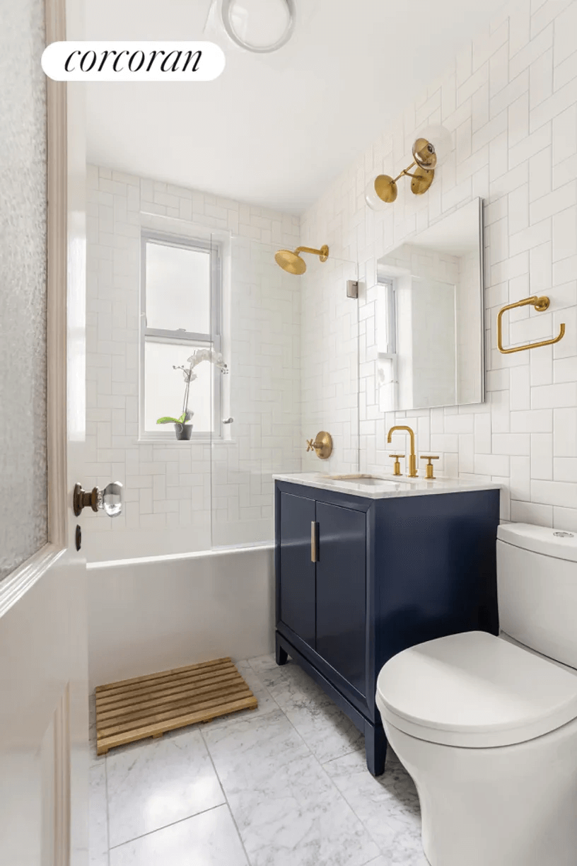 bathroom with dark blue vanity and white fixtures