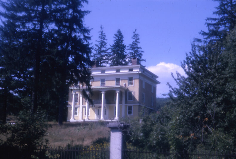color slide of the house showing a bit of the fence with the yellow and white house beyond