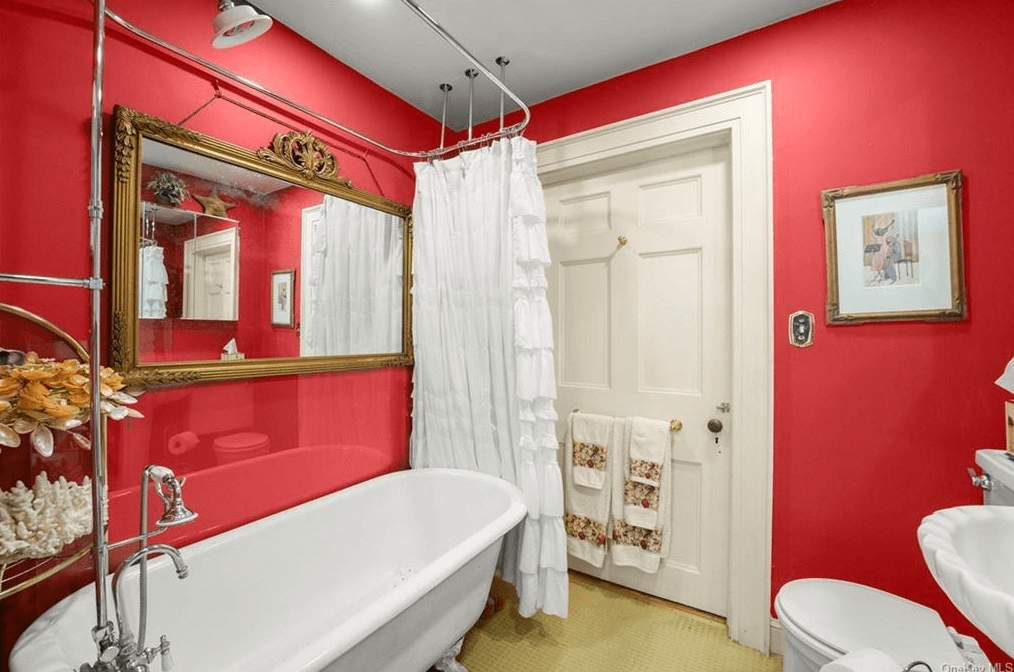bathroom with red walls and claw foot tub