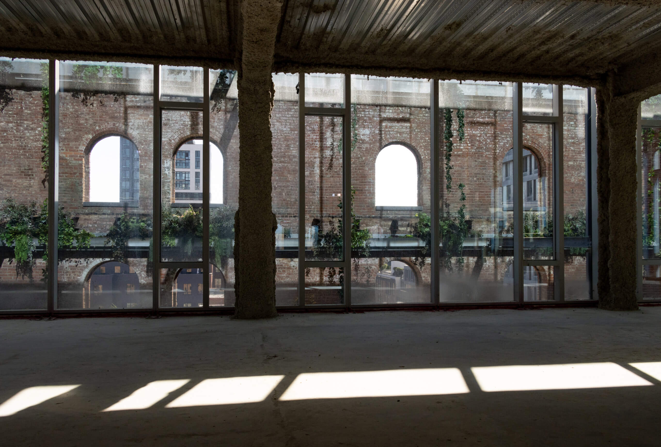 view out windows to original exterior wall with plants