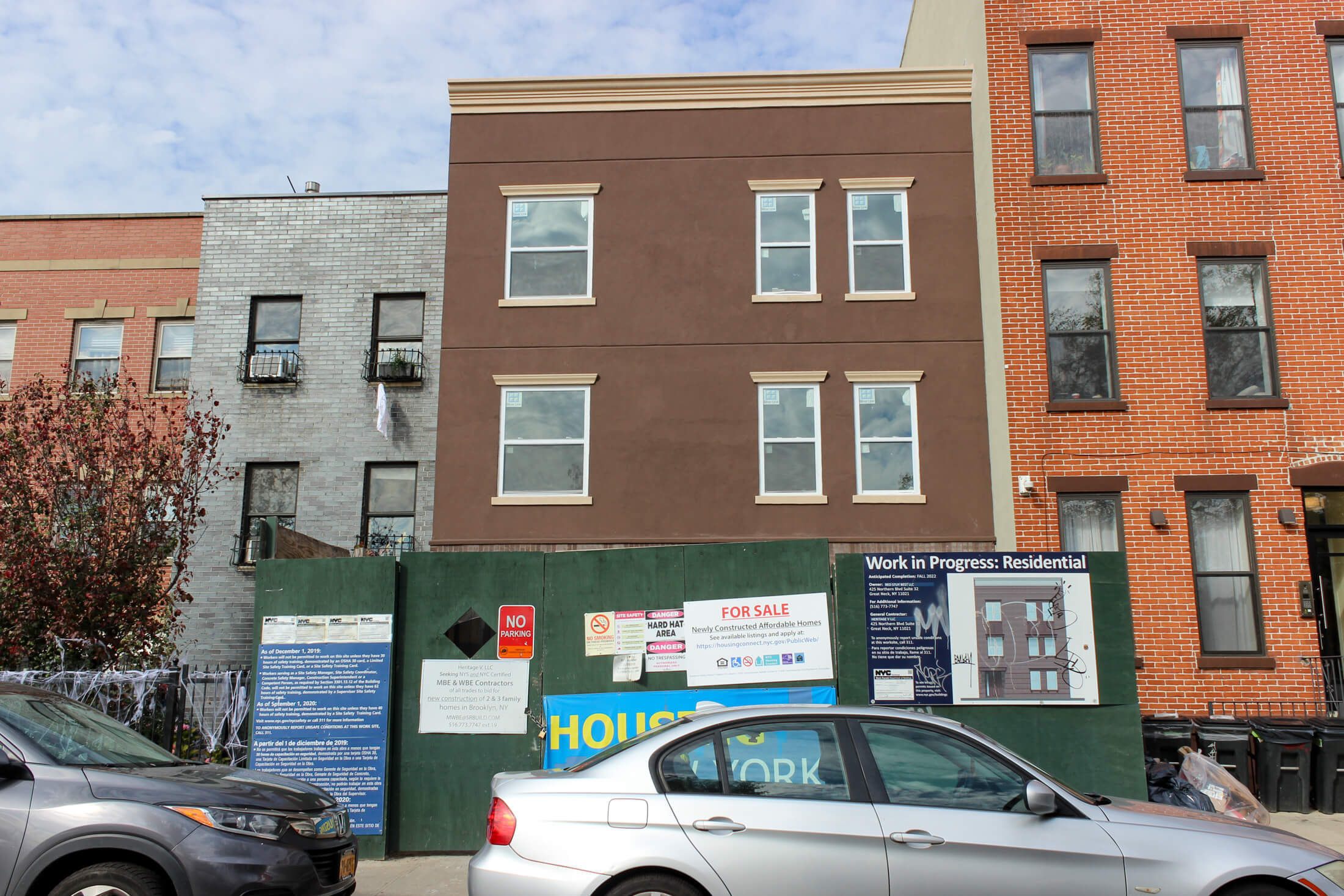 stucco covered exterior of a new house behind a construction fence