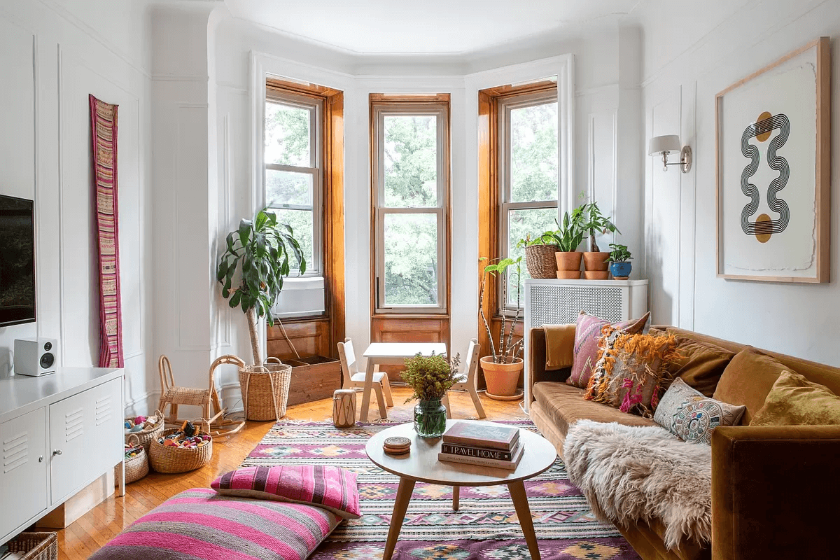 bed stuy - living room with bay window, wall moldings and wood floors