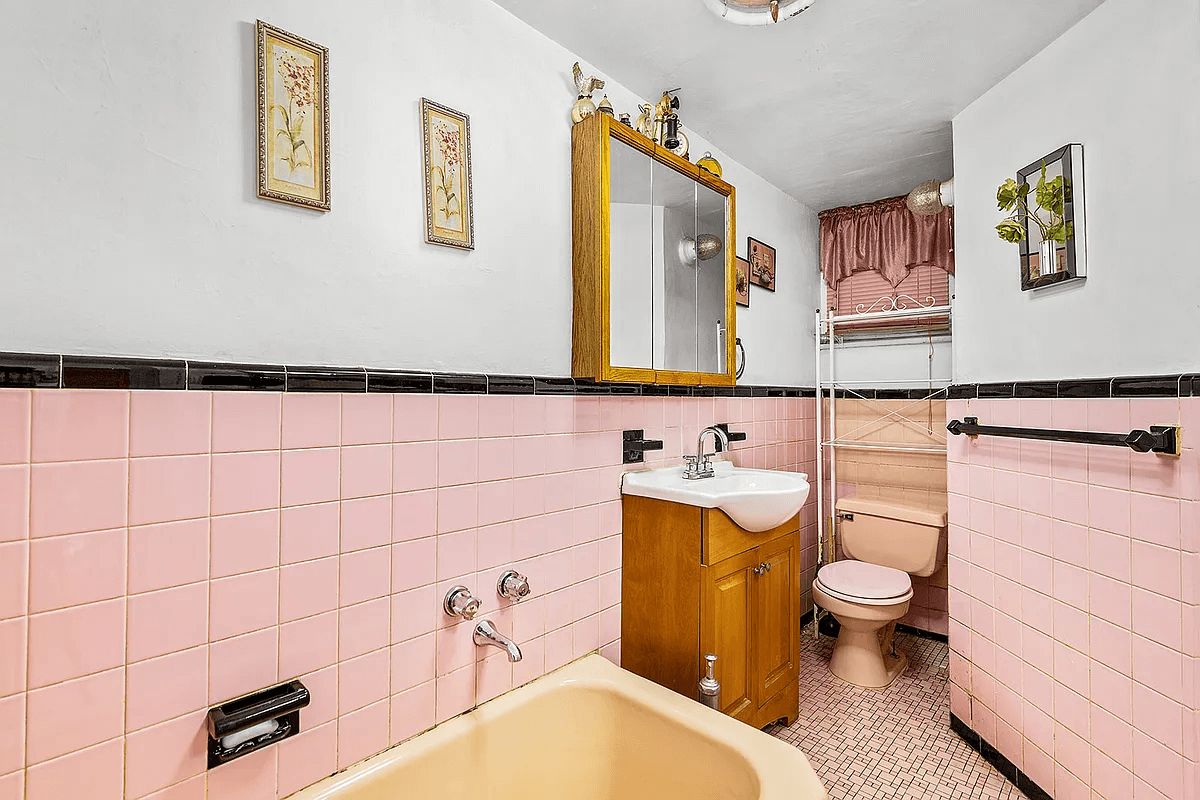 bathroom with vintage pink wall tiles and toilet and black accessories and trim tile