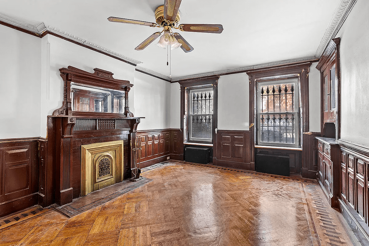 garden level original street facing dining room with built-in china cabinet and a wood mantel with mirror