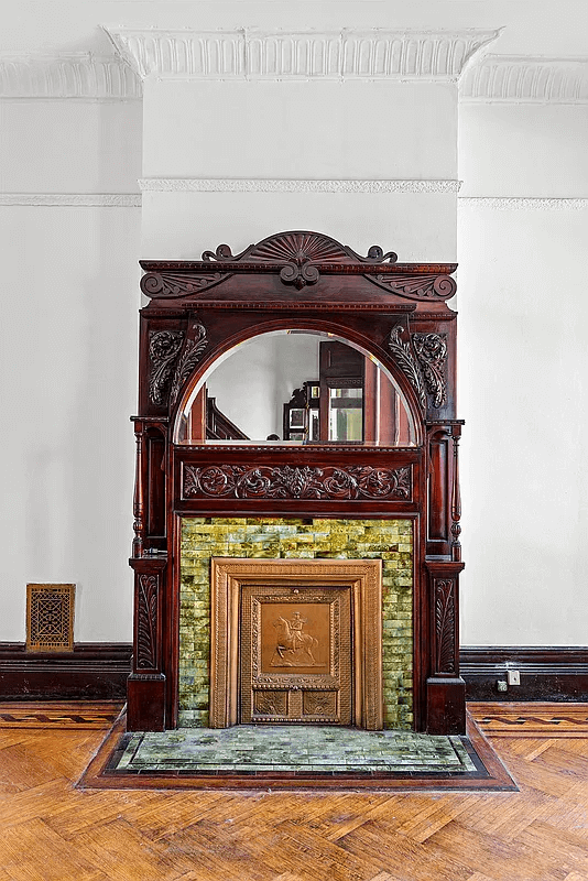 wood mantel with original green tile surround and ornamental insert