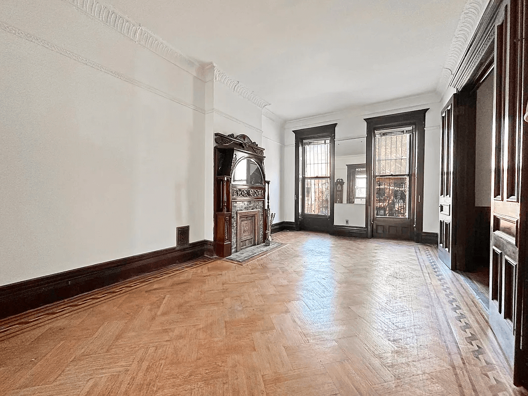 parlor with wood floor with inlaid border and a mantel