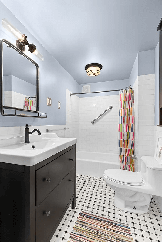 bathroom with white tile and fixtures and a dresser vanity