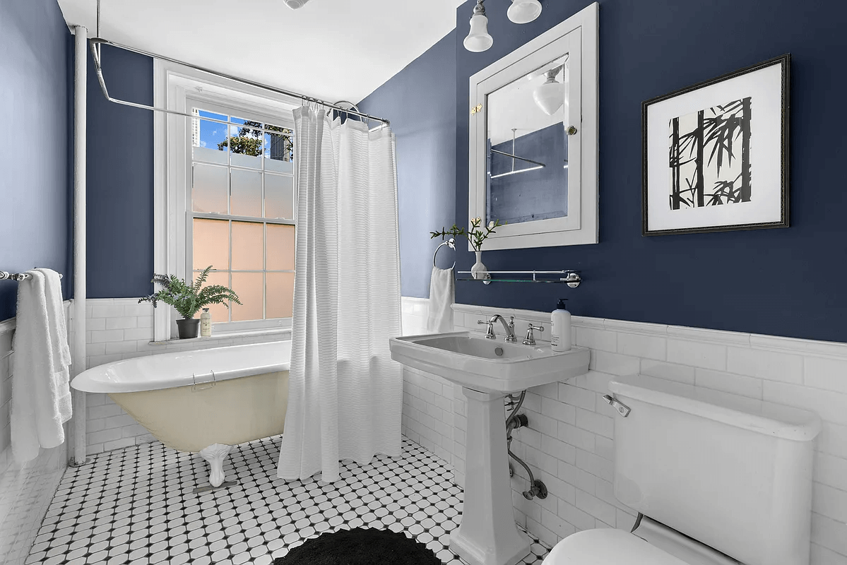 bathroom with claw foot tub and a pedestal sink