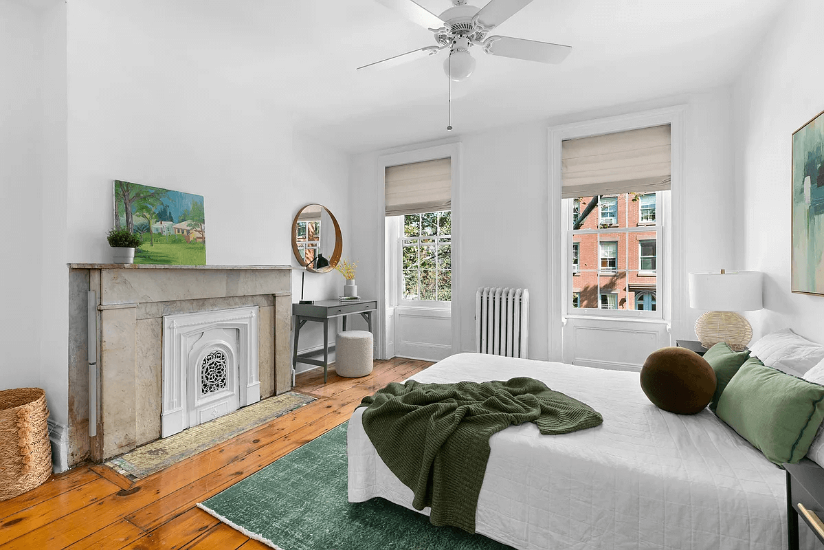 bedroom with a marble mantel and a ceiling fan