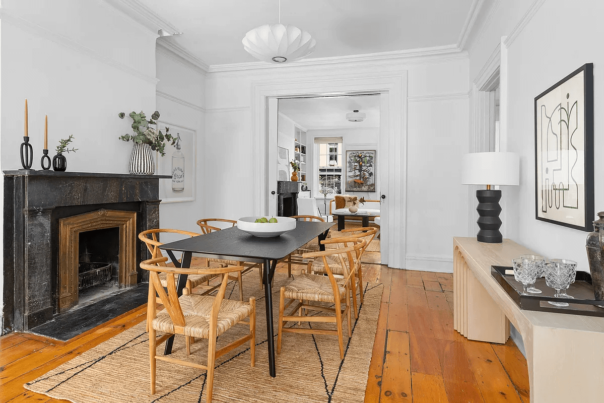 dining room with a black marble mantel and wood floors