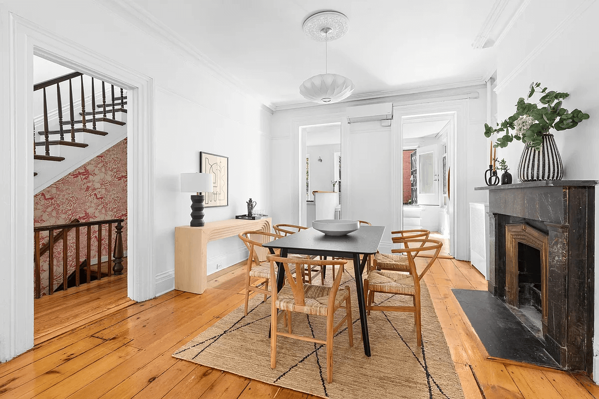 dining room with a black marble mantel and wood floors