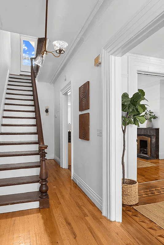 entry with wooden newel post and narrow stair