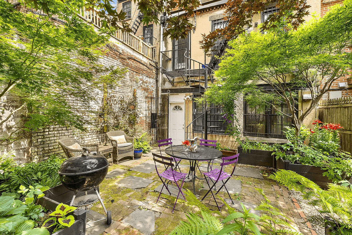 rear yard with stone and brick patio and raised planters