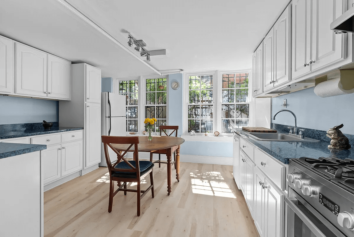garden level kitchen with white cabinets and pale wood floors
