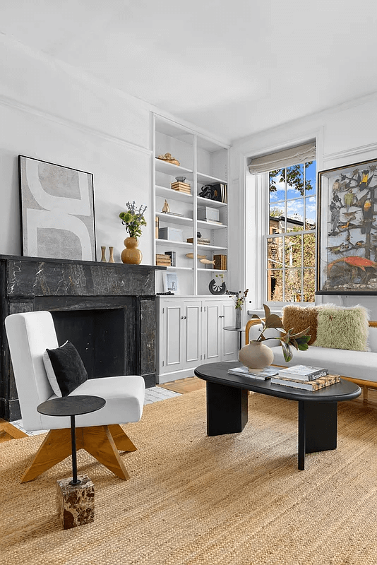 parlor with black marble mantel and modern built-ins