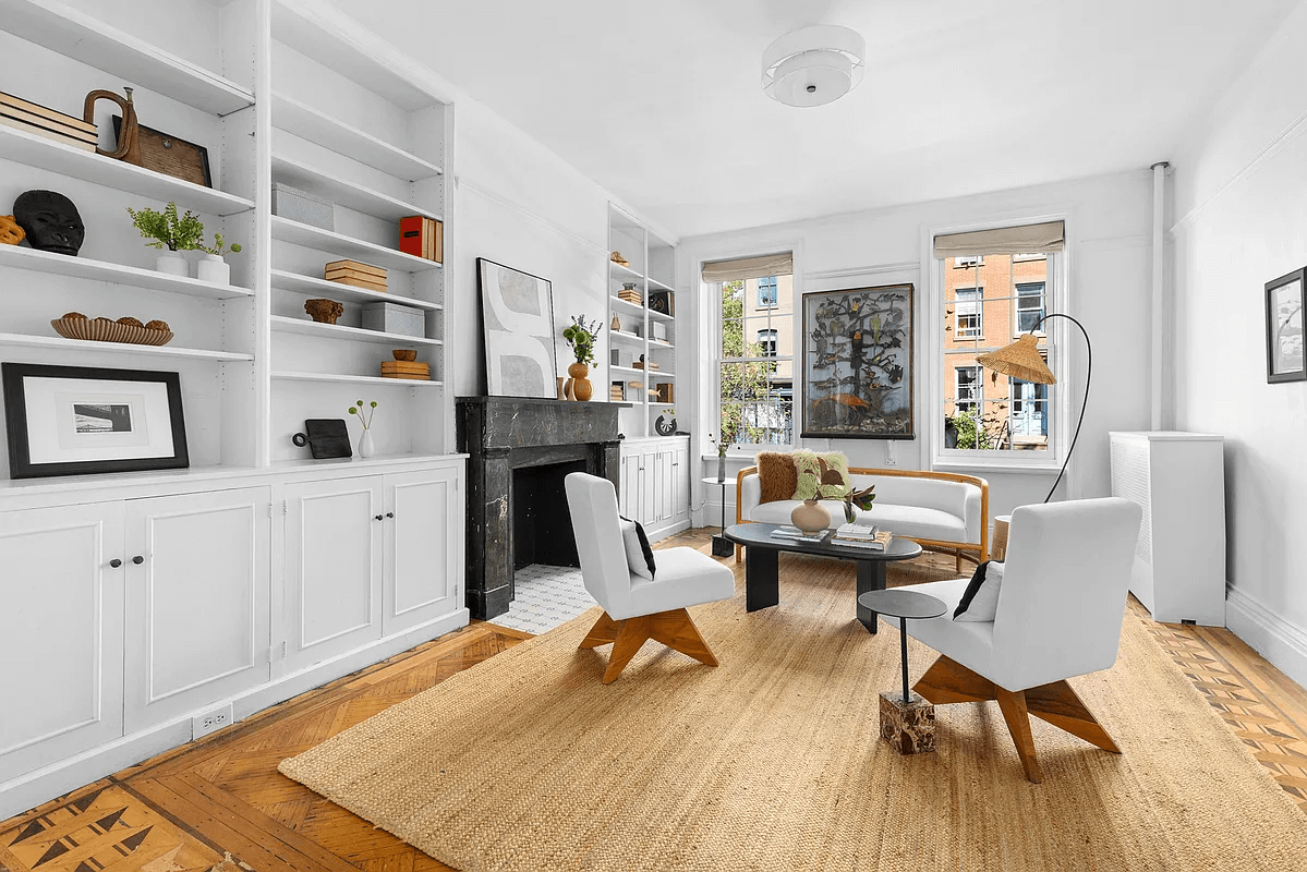 parlor with black marble mantel and modern built-ins