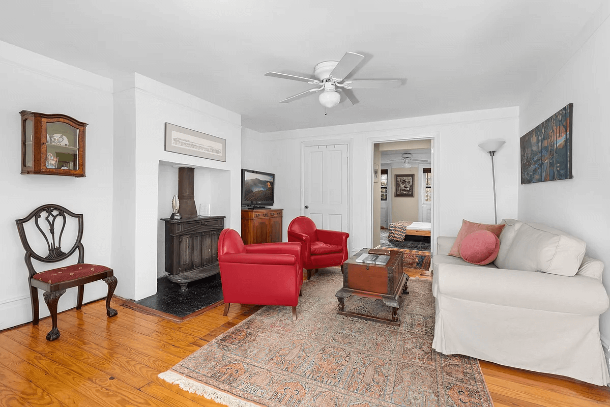 sitting room with ceiling fan and wood stove