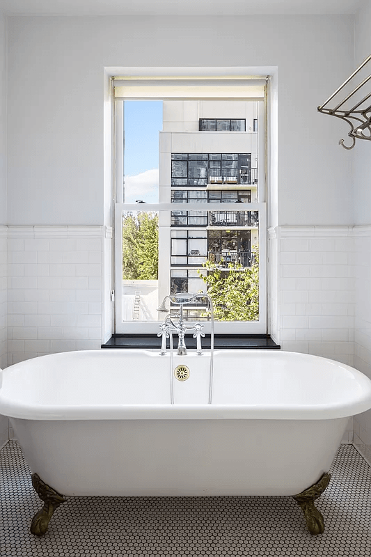 claw foot tub in front of a window