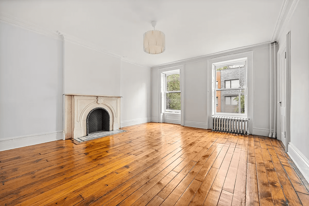 bedroom with marble mantel and wood floor